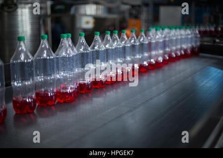 Bottiglie di succhi di frutta sul nastro trasportatore in bevande fabbrica di produzione Foto Stock