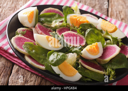 Gustosa insalata di anguria ravanelli, uova, spinaci e erbe closeup su una piastra orizzontale. Foto Stock