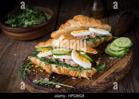 Tonno croissant panini sul tagliere di legno. Freschi e saporiti insalata di tonno panini. Foto Stock