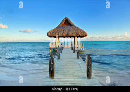 Tropical spiaggia di sabbia bianca. Di foglie di palma di legno coperto pier con gazebo sulla spiaggia. Punta Cana, Repubblica Dominicana Foto Stock