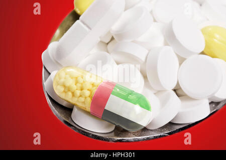 La bandiera nazionale degli Emirati arabi uniti in una capsula e pillole su un cucchiaio.(serie) Foto Stock