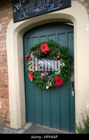 Benvenuto la corona di Natale sulla porta d'ingresso Foto Stock