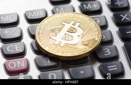 Golden bitcoin coin sulla calcolatrice close up Foto Stock