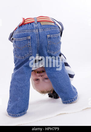 Kleiner, lustiger Junge schaut zwischen seinen Beinen durch - funny, Little Boy, Modello rilasciato Foto Stock