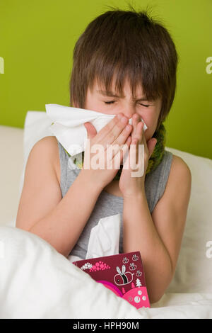 Junge Kranker schneuzt sich im Bett - ragazzo malato nel letto soffia il naso, Modello rilasciato Foto Stock