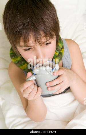 Junge Kranker mit Tasse Tee Bett im - ragazzo malato con la tazza di tè in letto, Modello rilasciato Foto Stock