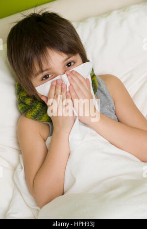 Junge Kranker schneuzt sich im Bett - ragazzo malato nel letto soffia il naso, Modello rilasciato Foto Stock