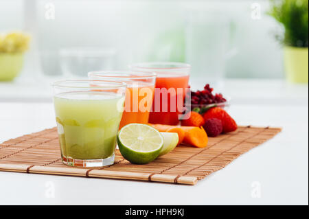 Succhi di frutta colorati e i loro ingredienti naturali: mela verde e calce, carota, fragole e melograno: dieta sana nozione Foto Stock