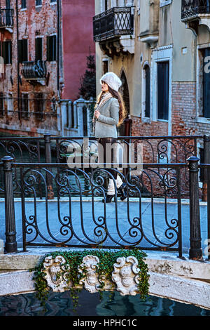 Venezia. Itinerario insolito. A piena lunghezza ritratto del viaggiatore eleganti donna in pelliccia hat a Venezia, Italia in inverno godendo promenade Foto Stock