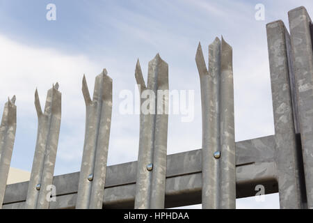 Picchi in acciaio galvanizzato sulla parte superiore di un cancello di sicurezza o recinzione Foto Stock