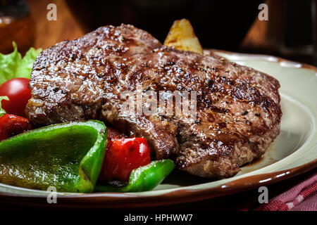 Porzioni di grigliate di carne di manzo servito con patate alla griglia e paprica Foto Stock