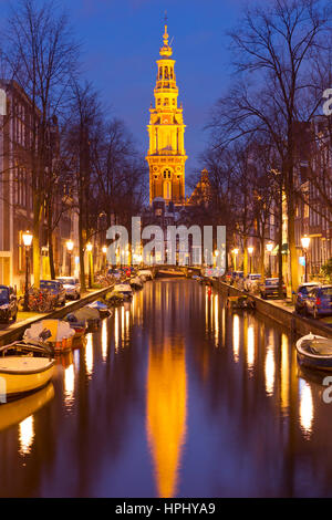 Torre di una chiesa alla fine di un canale nella città di Amsterdam, Paesi Bassi durante la notte. Foto Stock