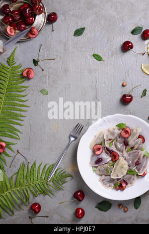 Ciliegio dolce gnocchi di patate, con frutti di bosco freschi. Vista superiore, copia dello spazio. Foto Stock