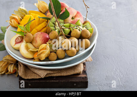 Frutta tropicale con piastra di mango, albicocche, longan e kiwi Foto Stock