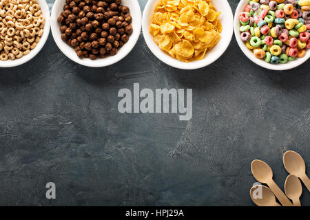 Varietà di cereali freddi in bianco bocce, veloce colazione per bambini overhead shot con copyspace Foto Stock