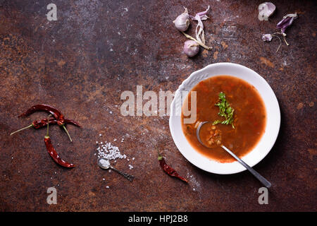 Zuppa del giorno. Pomodoro e peperoncino gazpacho con ingredienti uovere sfondo rustico. Vista superiore, copia dello spazio. Foto Stock