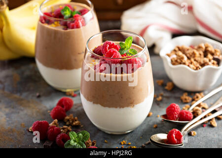 Banana e cioccolato Semifreddo di yogurt con granola e lamponi Foto Stock