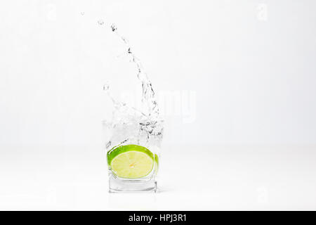 Il tiglio è caduta in acqua isolati su sfondo bianco Foto Stock