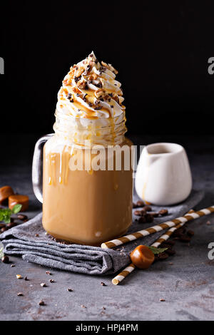 Caramello latte ghiacciato con panna e sciroppo su sfondo scuro Foto Stock