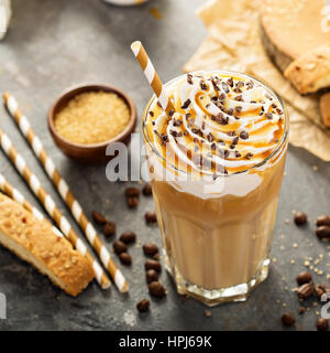 Iced caramello latte caffè in un bicchiere alto con sciroppo e panna montata Foto Stock
