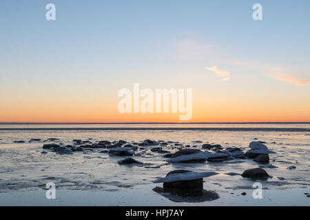 Twilight vista in un gelido e Costa sassosa con bellissimo cielo colorato Foto Stock