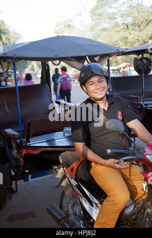 Un Tuk Tuk driver in attesa per i suoi passeggeri i turisti in visita a Angkor Wat - Siem Reap - Cambogia Foto Stock