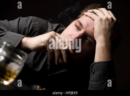 Modello rilasciato , Frustrieter Mann mit alcol und Zigarette - frustrato uomo con alcool una sigaretta Foto Stock