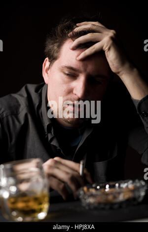 Modello rilasciato , Frustrieter Mann mit alcol und Zigarette - frustrato uomo con alcool una sigaretta Foto Stock