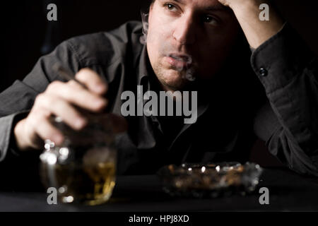 Modello rilasciato , Frustrieter Mann mit alcol und Zigarette - frustrato uomo con alcool una sigaretta Foto Stock