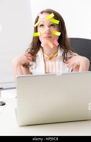 Modello rilasciato , Bueroangestellte mit vielen Post-Its im Gesicht - commesso con molti dei post-it sulla faccia Foto Stock