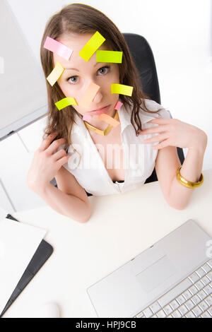 Modello rilasciato , Bueroangestellte mit vielen Post-Its im Gesicht - commesso con molti dei post-it sulla faccia Foto Stock