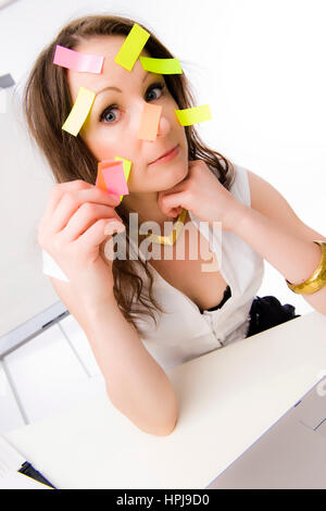 Modello rilasciato , Bueroangestellte mit vielen Post-Its im Gesicht - commesso con molti dei post-it sulla faccia Foto Stock