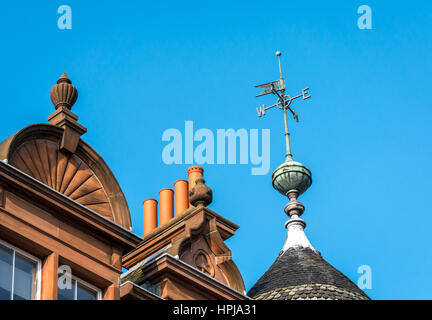 Vista ravvicinata di weathervane sul tetto dell'antico edificio vittoriano in arenaria rossa con vasi di camino a Leith, Edimburgo, Scozia, Regno Unito Foto Stock