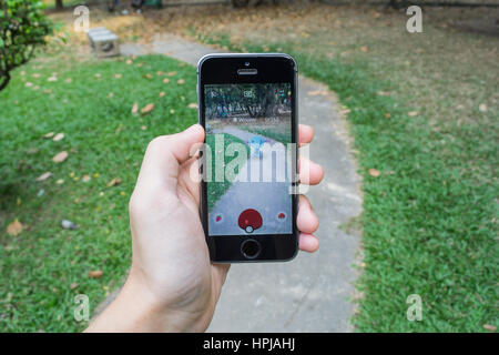 Bangkok, Tailandia - 22 Febbraio 2017 : Apple iPhone5s tenuto in una mano che mostra il suo schermo con Pokemon Go. Foto Stock