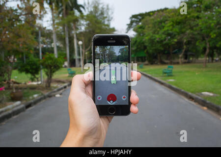 Bangkok, Tailandia - 22 Febbraio 2017 : Apple iPhone5s tenuto in una mano che mostra il suo schermo con Pokemon Go. Foto Stock