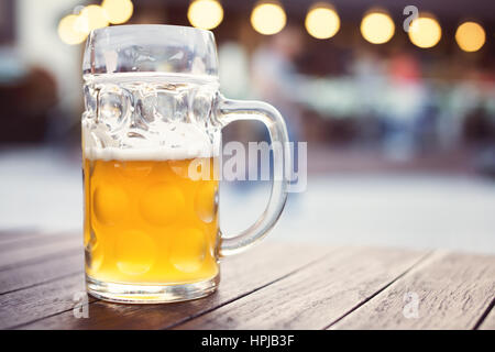 Il vetro artigianale di birra chiara sulla tabella pub. Maschiato birra non filtrata. Profondità di campo Foto Stock