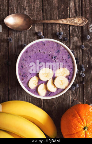 Deliziosi frutti di banana e berry smoothie frullato su legno rustico. Lay piatto. Profondità di campo Foto Stock