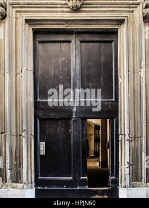 Legno antico porta in legno di quercia con cornice in marmo del portale sul vecchio muro in mattoni, Urbino, Italia. Foto Stock