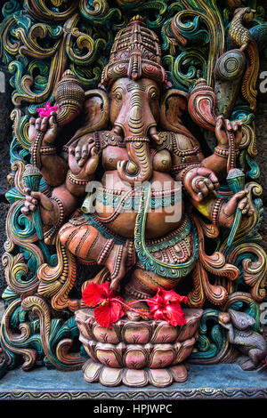 Ganesha statua con bel rosso fiori di ibisco presso il Tempio Hundu sull'Isola di Kauai. Foto Stock
