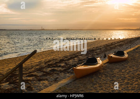 Due kayak in attesa sulla spiaggia sotto un brillante tramonto in Truro, Cape Cod Massachussets Foto Stock