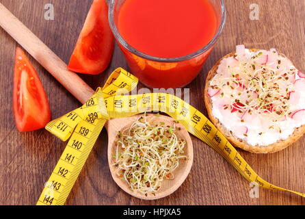 Fresco sandwich vegetariano con formaggio, verdure, erba medica e i germogli di rafano, bicchiere di succo di pomodoro e nastro di misurazione, dimagrimento vita sana Foto Stock