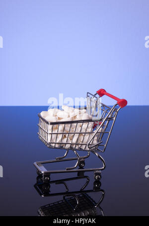 Carrello spesa riempiti con la medicina, isolati su nero sfondo lucido Foto Stock