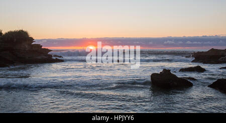 Punakaiki, Paparoa National Park, West Coast, Nuova Zelanda. Vista sul mare dalla baia isolata che segna la fine della pista di Truman, il tramonto. Foto Stock