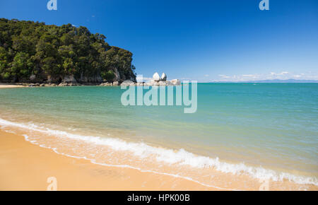 Kaiteriteri, Tasmania, Nuova Zelanda. Vista di Split Rock Apple dalla spiaggia sabbiosa di torri Bay. Foto Stock
