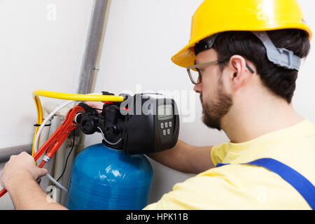 Plumber installazione di nuova acqua sistema di filtrazione Foto Stock