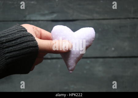 Scheda per il giorno di San Valentino, vintage, stile mano che tiene a cuore. Foto sfocate per lo sfondo. Foto Stock