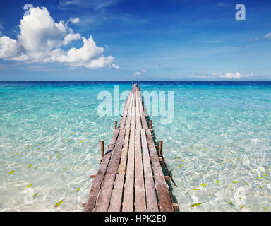 Il molo di legno su un isola tropicale, un mare limpido e azzurro del cielo Foto Stock