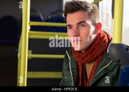 Giovane uomo sul bus a guardare in profondità nel pensiero. Foto Stock
