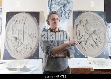 Ottendorf-Okrilla, Germania. Il 22 febbraio, 2017. Scultore Jan Kretzschmar è in piedi di fronte a due rilievi ovali della storica soffitto in stucco di Francoforte "scala d'Oro" presso il laboratorio di Fuchs e Gierke Bau und Denkmalpflege GmbH in Ottendorf-Okrilla, Germania, 22 febbraio 2017. La replica di 37 metri quadri, riccamente decorata con soffitti in stucco dal primo piano della Frankfurt casa in legno e muratura è stata realizzata da esperti di Sassonia. Il progetto ha un costo di circa 250.000 euro. Credito: dpa/Alamy Live News Foto Stock