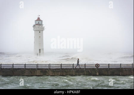 New Brighton, Wirral, Regno Unito. Il 23 febbraio, 2017. Un uomo cammina lungo la promenade, passato il faro, come tempesta Doris colpisce il Wirral peninsula costa, con forti venti e piogge. Credito: Paolo Warburton/Alamy Live News Foto Stock